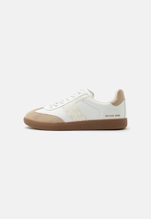 Baskets basses blanches et beiges avec semelle marron et lacets à l'avant, avec un panneau latéral texturé et le logo "Michael Kors" au talon.