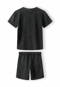 Svart kortärmad t-shirt för barn och matchande shorts, med en enkel design, mjukt tyg och elastisk midja för komfort.
