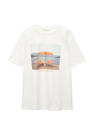 Witte katoenen t-shirt met een grafisch ontwerp van twee oranje stoelen onder een parasol aan de kust, met de tekst "GEBRAND HUID & ROMMELIG HAAR."