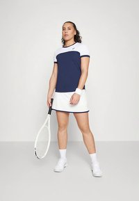 Completo da tennis blu navy e bianco composto da maglietta a maniche corte e gonna plissettata. La maglietta presenta blocchi di colore e una silhouette aderente.