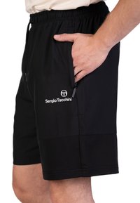 Schwarze Sportshorts mit einem elastischen Bund, Seitentaschen und einem strukturierten Abschnitt am Saum. Mit einem Logo auf dem Oberschenkel.
