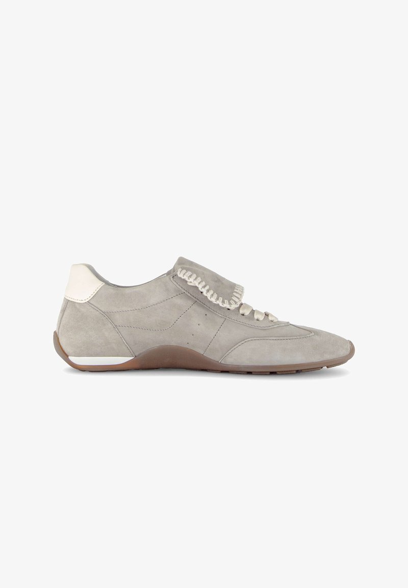 Baskets en daim gris clair avec un patch blanc au talon, des lacets beiges et une semelle en caoutchouc marron, présentées de profil sur un fond blanc.