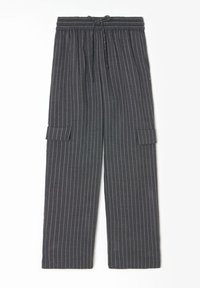 Pantalons à rayures noires et grises avec taille élastique, cordon de serrage et poches à rabat sur chaque cuisse, posés à plat sur un fond blanc.