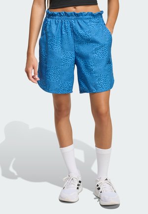 Niebieskie spodenki z teksturowanym wzorem zwierzęcym, elastycznym pasem i bocznymi kieszeniami. W połączeniu z białymi skarpetami i sneakersami.