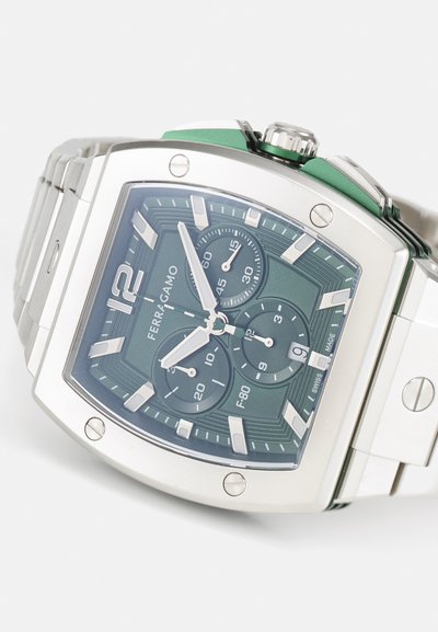 Square silver stainless steel watch with a green textured dial, three sub-dials, white hour markers, and a green accent on the crown.