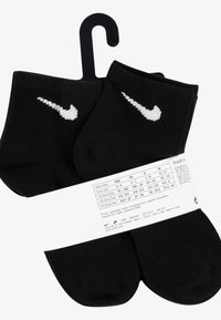 Sorte ankelokker med hvit Nike swoosh-logo. Laget av ribbestoff. Pakket med et papirbånd som viser størrelseinformasjon.