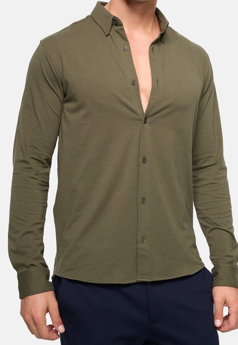 Olive green long-sleeve shirt with a button-down collar, featuring a v-neckline, brown buttons, and soft texture.