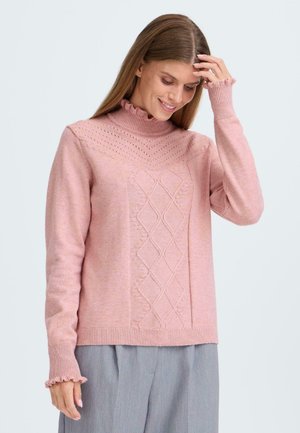 Rosa gestrickter Pullover mit hohem Kragen, auf der Vorderseite mit einem Rautenmuster und Rüschensäumen. Weicher Stoff und lockere Passform.