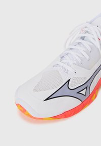 Weiße Sportschuhe aus Netz- und Synthetikmaterialien, mit grauen Akzenten und einer lebhaft orange-gelben Sohle mit einer strukturierten Musterung.