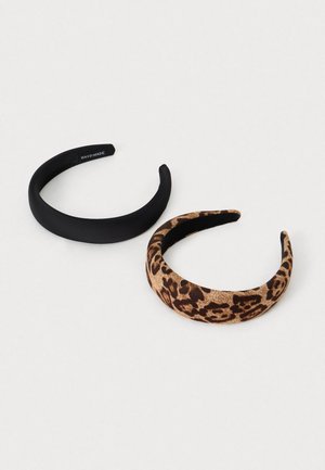 Two hairbands: one matte black, smooth surface; the other in leopard print fabric with a soft texture. Both curved, sturdy design.