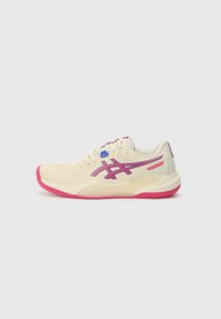 Chaussure de sport couleur crème avec une semelle rose, des accents bleus et violets, une tige perforée et un design à bout rond.