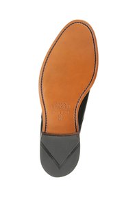 Sole in pelle marrone con inserto beige, dotata di marchio impresso e cuciture a contrasto, tallone in gomma nera testurizzata per una migliore aderenza.