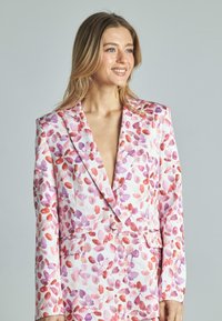 Blazer con motivo floreale in nuances di rosa, viola e rosso, realizzato in tessuto liscio con rever a barchetta e tasche frontali.