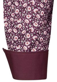 Blumenmusterstoff in lila und weißen Farbtönen, mit kleinen Blumen und roten Mittelpunkten. Design mit umgeschlagenen Ärmeln und einfarbigem burgunderfarbenem Saum.