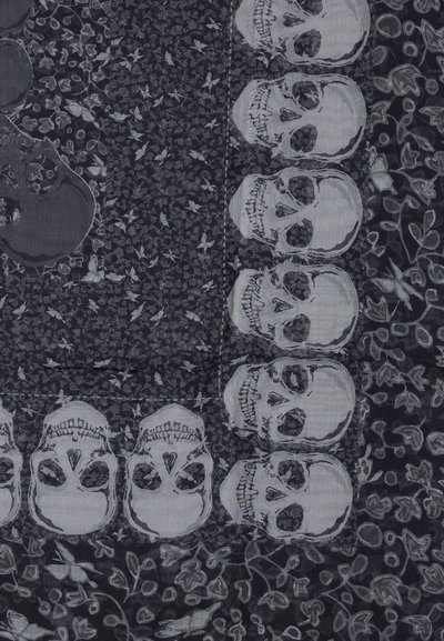 Υφασμα με διακοσμητικά σχέδια, σειρές με στυλιζαρισμένα κρανία και μοτίβα πεταλούδας σε ένα υφή σκοτεινό φόντο.