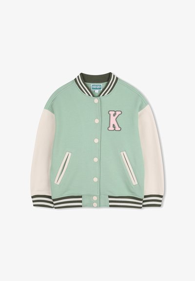 Veste universitaire vert menthe avec manches blanches, col et poignets côtelés. Présente un grand patch "K" rose et des boutons-pression à l'avant.