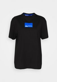 Camiseta de manga corta negra hecha de algodón. Presenta un gráfico rectangular azul con el texto "KARL LAGERFELD JEANS" en blanco. Corte clásico.