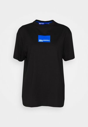 Czarny krótki rękaw t-shirt wykonany z bawełny. Posiada prostokątną niebieską grafikę z napisem "KARL LAGERFELD JEANS" na białym tle. Klasyczny krój.