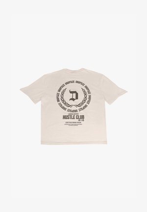 Valge lühikeste varrukatega T-särk, mille seljal on suur must graafika, kus on kiri "D" ja laureli muster, sildiga "PIIRATUD VERSIOON HUSTLE CLUB".