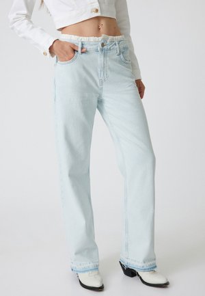 Jeans de mezclilla azul claro con cintura alta y cinturilla elástica. Tienen piernas rectas, un sutil detalle de costura y un ligero desgaste en el dobladillo.