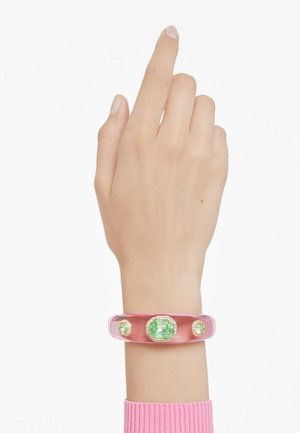 Pink acrylic bracelet featuring three green gemstones, including an octagonal centerpiece, with gold accents and a smooth finish.