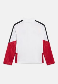 Balts sporta tops ar garām piedurknēm, sarkanām teksturētām apakšējām piedurknēm un melnām svītrām plecos un augšējās rokās.