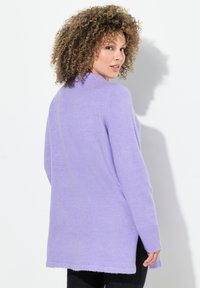 Maglione lilla realizzato in materiale morbido, con una vestibilità rilassata, maniche lunghe, spacchi laterali e orlo a costine. Adatto per un abbigliamento casual.