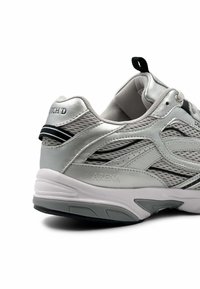 Zilveren sportschoen met een mesh bovenzijde, gewatteerde kraag en zwarte accenten. Beschikt over een gevoerde zool en reliëf merkdetails op de hiel.