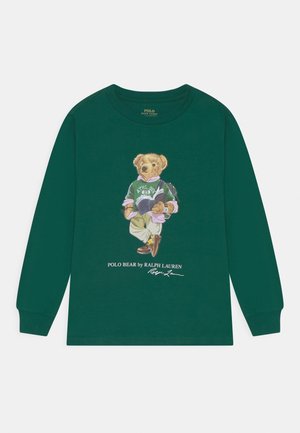 Ciemnozielona koszulka z długim rękawem z grafiką niedźwiedzia w codziennym ubraniu z książką, z białym tekstem poniżej i starannym przeszyciem.