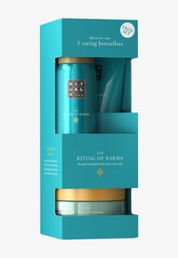 Zestaw próbny Rituals w turkusowym opakowaniu, zawierający trzy produkty: dwie puszki i jeden słoik z złotymi akcentami, oznaczone jako "Rytuał Karmy."