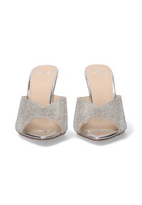 Mules destalonados con un upper de purpurina plateada y un diseño en forma de V. Presentan una plantilla en tono marrón y acentos brillantes en el tacón metálico.