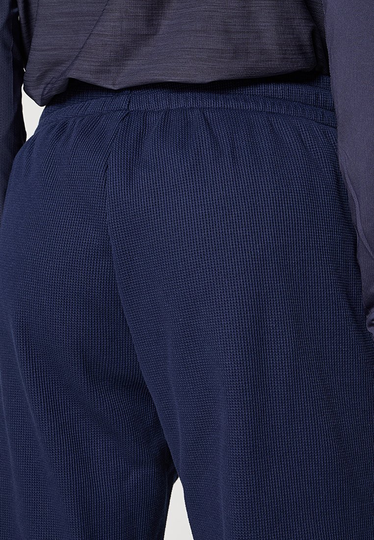 Marineblauwe breipantalons met een textuur en een elastische tailleband, met een ontspannen pasvorm en minimale zichtbare stiksels.