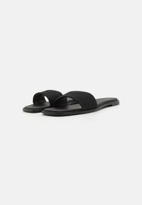 Black slide sandals made of fabric with wide straps, flat soles, and a slightly textured finish. No prominent logos or decorative elements.