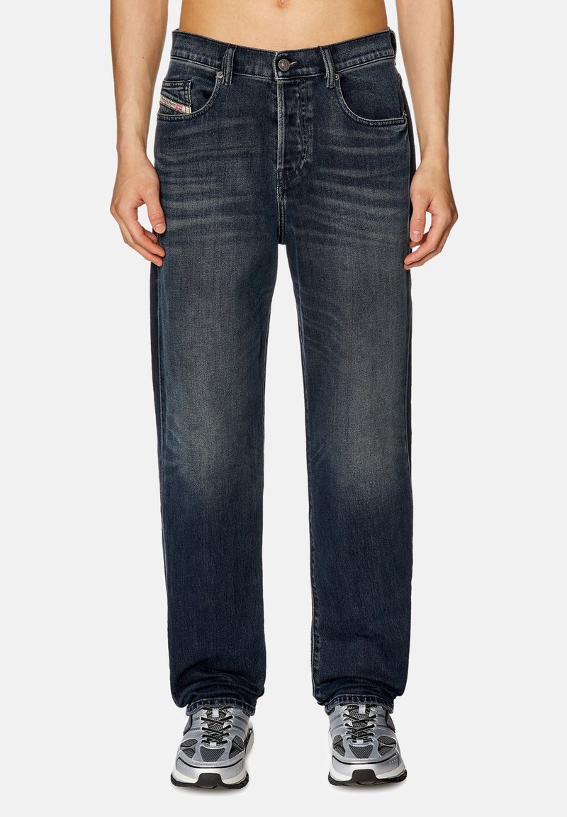 Dunkelblaue Denim-Jeans mit lockerer Passform, die dezente Färbung aufweisen, ein klassisches Fünf-Taschen-Design haben und mit geradem Bein bis zum Knöchel enden.