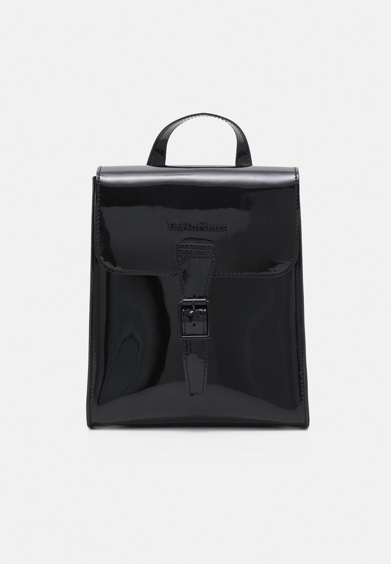 Sac à dos en cuir noir brillant avec poignée supérieure, rabat avant et fermeture à boucle, affichant le logo Dr. Martens embossé à l'avant.