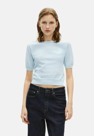 Lichtblauwe korte mouwen trui met een aansluitend ontwerp en geribde zoom. Gecombineerd met hoge taille donkere denim broek met contrasterende stiksels.