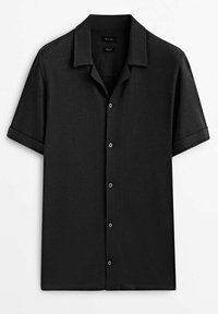 Chemise noire à manches courtes avec boutons, col campagnard et poignets retroussés, présentée à plat sur fond blanc.