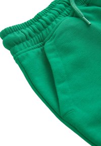 Groene sweatpants met een elastische tailleband met geplooide textuur, zijzakken en een gladde katoenen afwerking.