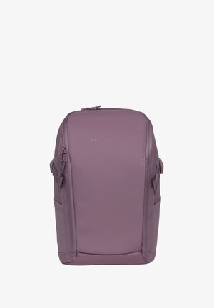Rektangulær lavendelfarget ryggsekk med to glidelåser på sidene, sidelommer og toppglidelås, stående oppreist mot en ensfarget hvit bakgrunn.