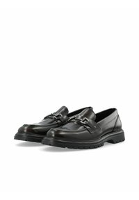 Mocasines de cuero negro con una suela de goma gruesa, acentos de hardware metálico y un acabado suave con un diseño de punta redonda.