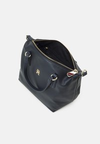 Marineblaue Lederhandtasche mit goldenen Beschlä GEN, runder Form und Reißverschluss. Das Innere verfügt über eine Reißverschlusstasche zur Organisation.