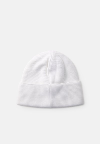 Vit stickad mössa med ribbat mönster, som har en vikbar kant och rundad topp, designad för värme och komfort.
