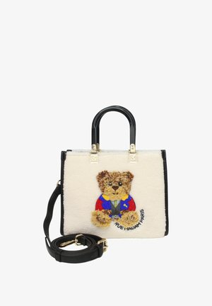 Sac à main en fausse fourrure blanche avec des accents noirs, présentant une broderie d'ours en peluche vêtue de manière colorée et une bandoulière noire amovible.
