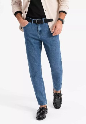 Lyseblå denim jeans med en tapered fit, parret med et sort bælte og blanke sorte sko. Jeansene har et klassisk fem-lomme design.