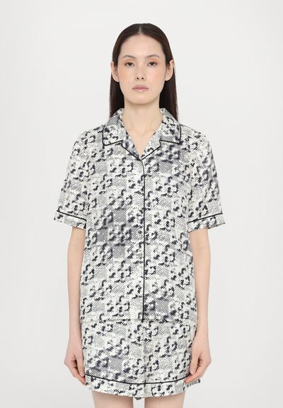 Pijamas de manga corta y cuello en un patrón abstracto en blanco y negro con bordes ribeteados, presentando un corte relajado y una tela ligera.