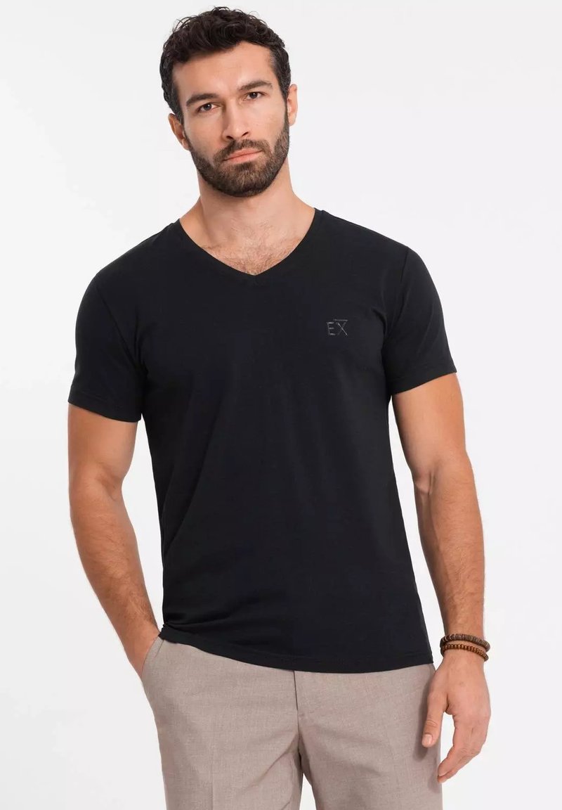 Czarny bawełniany t-shirt z dekoltem w szpic i krótkimi rękawami. Posiada małe logo "EX" na lewej piersi. Gładka tekstura.