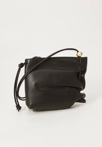 Crna kožna torba s mekim, naboranim dizajnom. Ima jedan dugi remen i zlatni kuglasti ukras na zatvaraču. Minimalno vidljivo brendiranje.