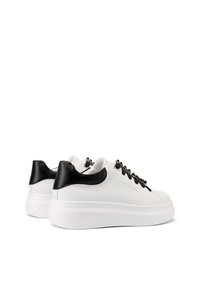 Sneaker bianchi con dettagli neri, finitura in pelle liscia, punta arrotondata, suola bianca spessa e lacci neri decorativi con dettagli metallici.