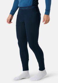 Leggings thermiques navy avec texture côtelée, une taille élastique comportant "SWEDEMOUNT," et une coupe fuselée, portés avec des chaussettes blanches.