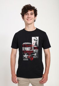 Černé bavlněné tričko s grafickým potiskem obsahujícím červené a šedé prvky, včetně textu "Přežil jsem kletbu Spellplague" a ikon z Dungeons & Dragons.